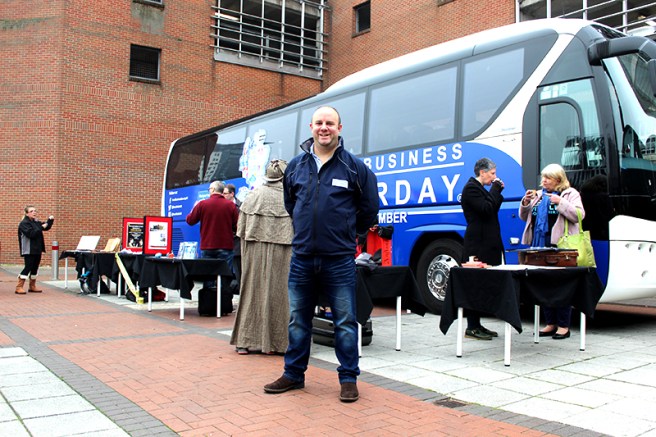 Tom Flynn, Director of operations of Small Business Saturday, stands in front of the bus.